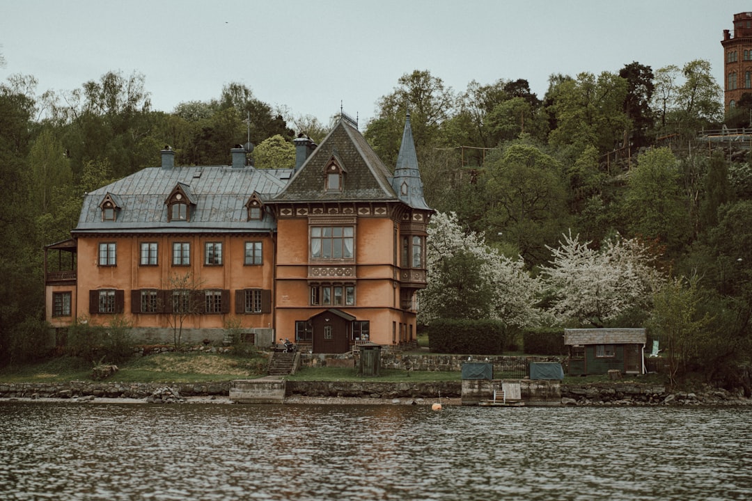 a large house sitting on top of a lake next to a forest